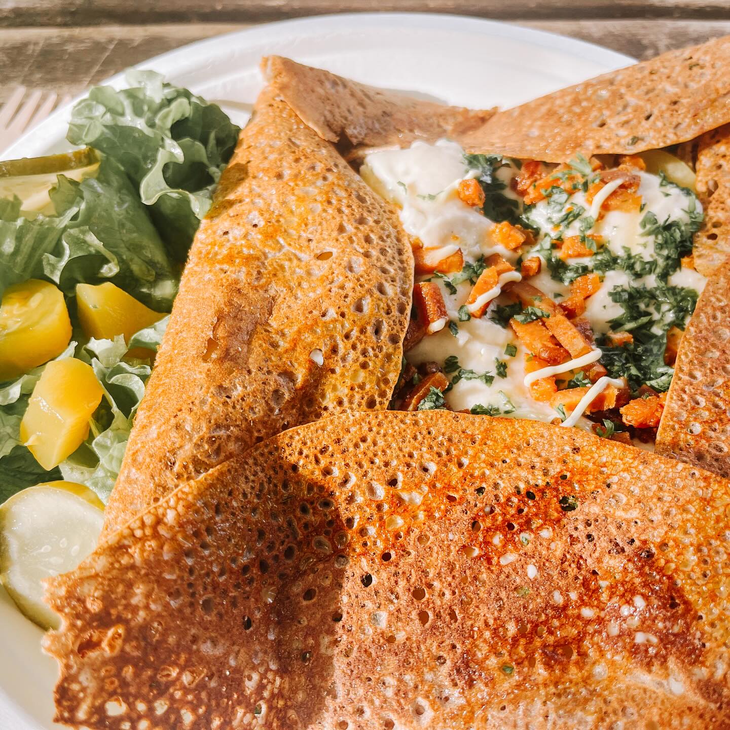 I discovered Paul Joly at the Green Market in Bordeaux, and I immediately fell in love with his booth. He’s known for intricate, delightful pâtisserie fine vegan desserts spanning from macarons and madeleines to elaborate Christmas logs and miniature works of art that look almost too beautiful to eat. What’s remarkable? Around 90% of his clients aren’t even vegan, they’re simply loyal customers who’ve been coming back for years because the quality speaks for itself.My favorite way to start market day is indulging in one of his savory offerings: galettes garnished with potato, vegan cheese, fresh herbs, and faux bacon, accompanied by a crisp side salad. It’s the perfect balance of comfort and elegance, proving that vegan food doesn’t have to choose between indulgence and sophistication. I think it’s wild to find this level of food at a green market, but hey, it’s France.Check @cuisinevegetalegourmande for rotating location at the green market📍Bordeaux, France🍄 fully vegan☀️Outdoor seating available at @greenmarketbordeaux